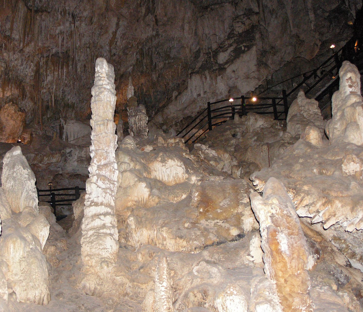 Stalagmiten und hängende Tropfsteine neben einer Treppe mit Geländer in der Ngilgi Cave.