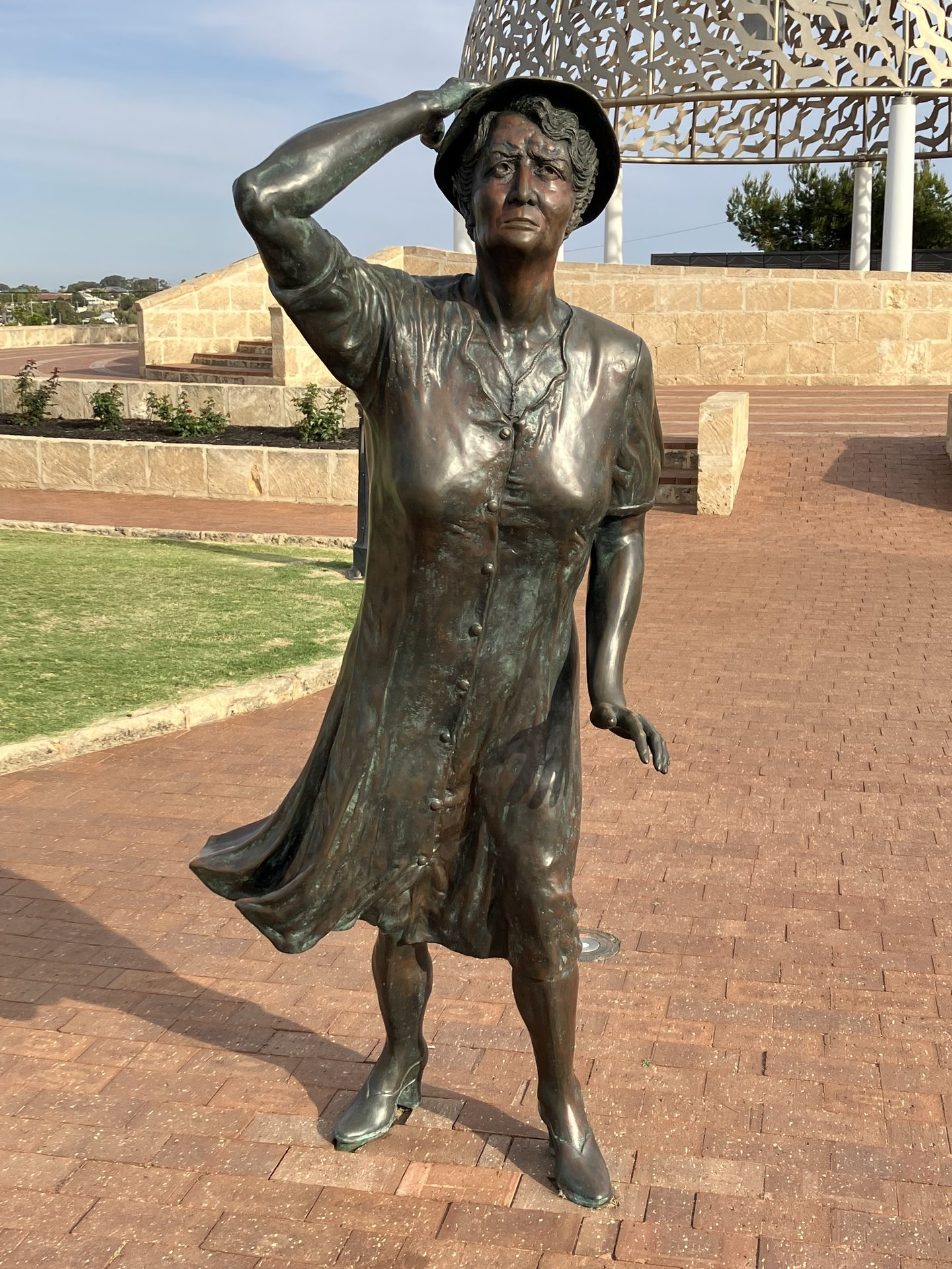 The bronze Waiting Woman shading her eyes at the HMAS Sydney II Memorial, with part of the Dome of Souls behind.
