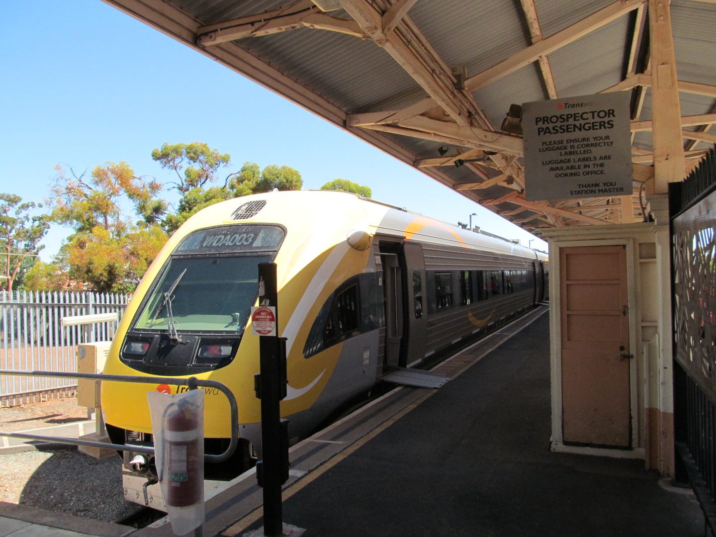 Ein gelb-silberner Prospector-Zug von Transwa am überdachten Bahnsteig in Kalgoorlie.